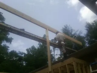 Carpenter setting a ridge beam over a new addition frame — Ice Dam Removal by Roofing Brothers in Lovelady