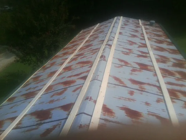 Rusted metal roof panels with new wood purlins before replacement — Storm Damage Roof Repair in Lovelady by Roofing Brothers