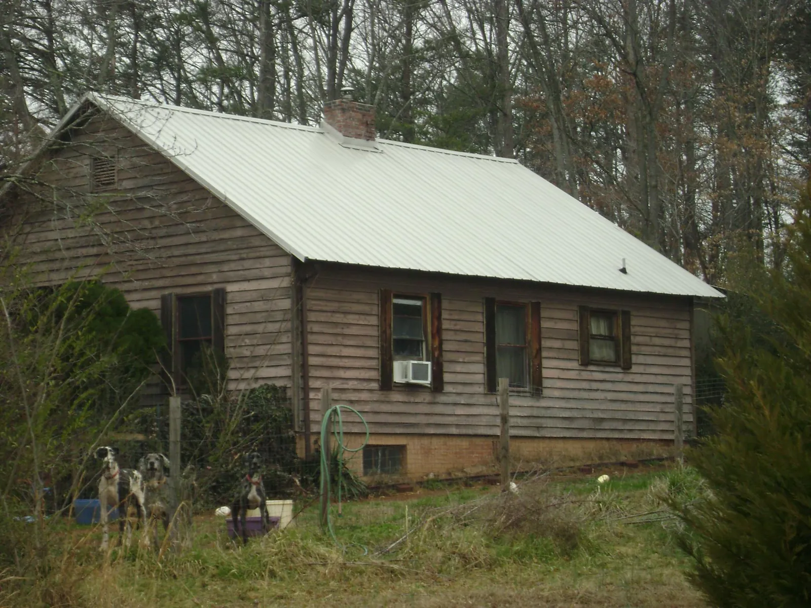 White metal roof on an old wood sided farmhouse, from a Metal Roof Installation job in Lovelady